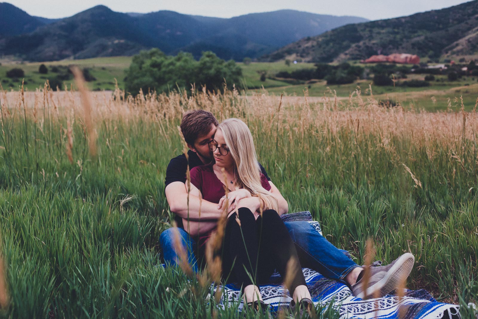 couple sitting in grass Summer engagement session - South Valley Park, Colorado